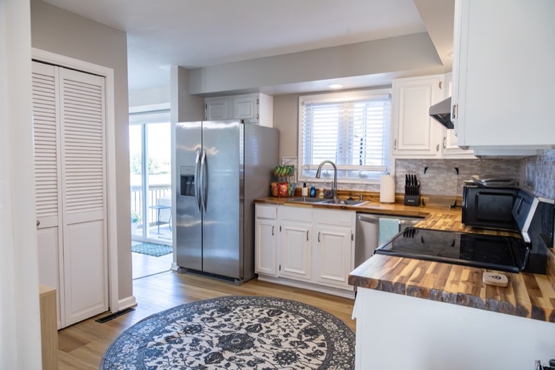 Renovated kitchen with butcher-block counters and stainless appliances