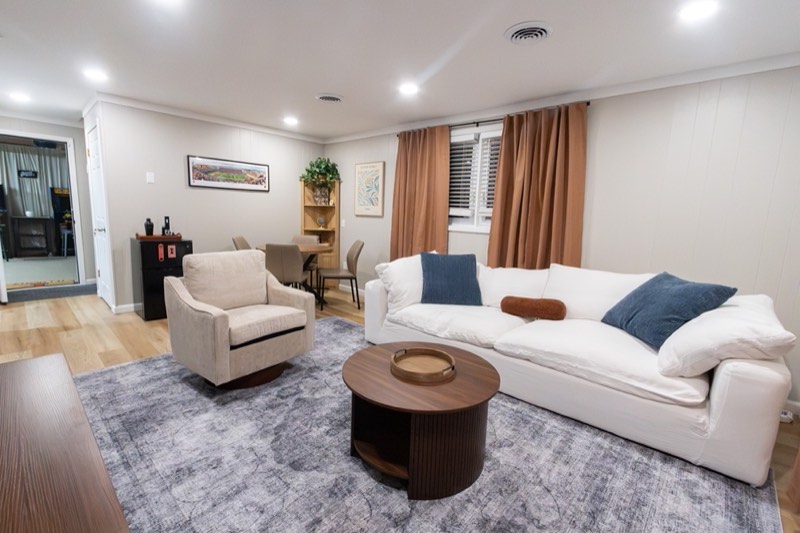 Downstairs living room with a white sofa and big TV