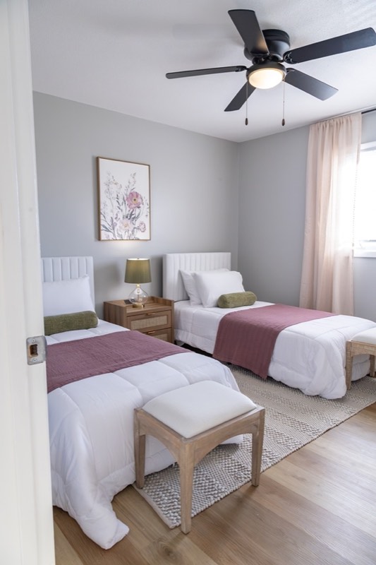 Twin bedroom with two beds and a ceiling fan